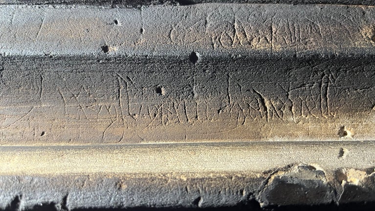 Early text, marks and engravings on the great hall stone fireplace at Stoneacre, Kent